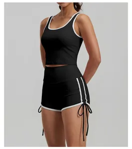 Vista laterale di top corto sportivo nero e pantaloncini da yoga a vita alta con coulisse