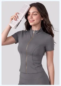 Vue détaillée d'une veste de yoga grise à manches courtes et fermeture éclair dorée.