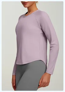 Vue latérale d'un haut de yoga ample violet à manches longues avec ourlet incurvé élégant