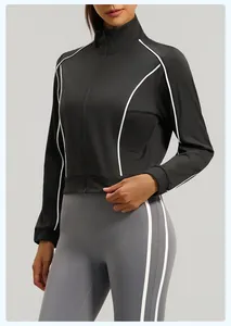 Detail view of a black zip-up sports jacket for women featuring white contrast piping