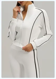 Detail view of a white fitness jacket featuring black contrast piping and zipper closure