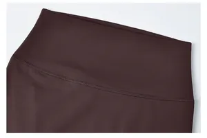Detailopname van een donkerbruine high-waist yoga legging met stevige platte naden