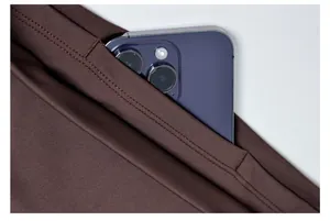Detailopname van een zak van een yogabroek met een paarse smartphone voor opslag