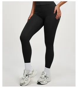 Détail d'un legging de yoga noir à taille haute et effet push-up porté par un mannequin