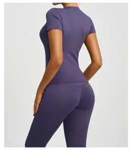 Close-up detail of a purple short-sleeve slimming yoga top and matching sports leggings