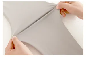 Gros plan montrant la haute élasticité du tissu gris clair des leggings de yoga