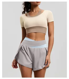 Professional studio detail shot of high-waist color-block yoga shorts and crop top outfit