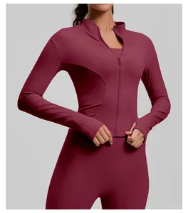 Detail of a burgundy slim-fit yoga jacket with zipper and thumbholes for sports training.
