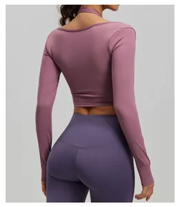 Achteraanzicht van een mauve yoga-top met lange mouwen en een paarse legging met hoge taille