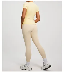 Back view of slim fit yellow yoga short sleeve and beige leggings