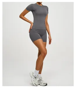 Side view of a woman wearing a gray short-sleeve yoga top and matching shorts for fitness