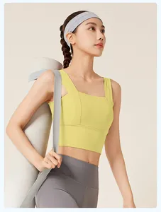 Detailansicht eines gelben Sport-BHs mit breiten Trägern und grauen Yoga-Leggings.