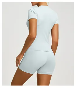 Back view of light blue slim fit short sleeve yoga top and matching athletic shorts set.