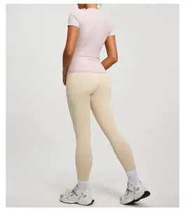 Detailed back view of women's slim pink short-sleeve yoga top and cream leggings.