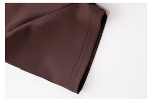 Detailed close-up showing the high-quality double-needle stitching on a brown yoga top hem.