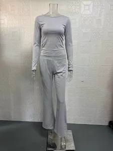 Dettaglio completo di un set grigio con top slim a maniche lunghe e pantaloni a zampa a vita bassa