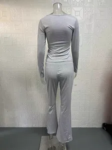 Vista posteriore di set grigio con top a maniche lunghe e pantaloni a zampa su manichino.