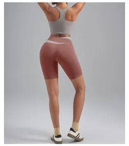 Back view of high-waisted peach lift yoga shorts in brick red with grey sports bra.