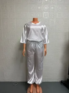 Close-up of white satin two-piece set featuring half-sleeve top and cargo pants