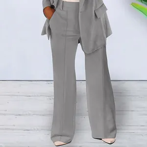 Detailed view of women's grey wide-leg suit trousers and slim-fit blazer outfit.
