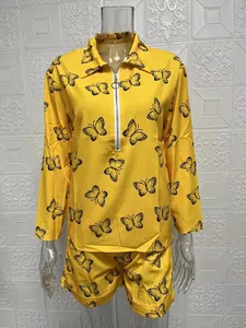 Detailed view of yellow long-sleeve top and shorts set with butterfly print