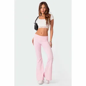 Vista a figura intera di crop top in pizzo bianco e pantaloni a zampa rosa aderenti