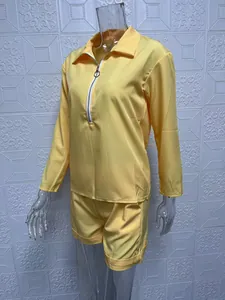 Close-up of women's yellow two-piece set with long-sleeve zipper top and shorts