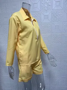Side view of women's yellow two-piece set with long sleeve zip top and shorts.