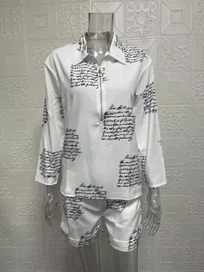 Detail of white two-piece set featuring script print long-sleeved top and shorts