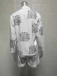 Close-up view of women's white two-piece set featuring elegant black cursive script print