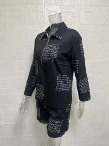 Detailed view of women's two-piece set featuring black fabric with white cursive print