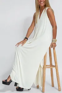 Elegante abito lungo senza maniche con scollo a V bianco su uno sgabello di legno