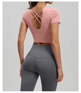 Detailansicht der Rückseite eines rosa Yoga-Tops mit überkreuzten Trägern und grauer Leggings