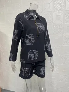 Black two-piece set with script print and zipper front detail on transparent mannequin