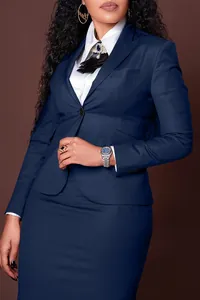 Detalle de conjunto de blazer y falda azul marino con camisa blanca y broche