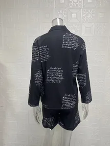 Back view of women's two-piece set with white cursive script print on black fabric