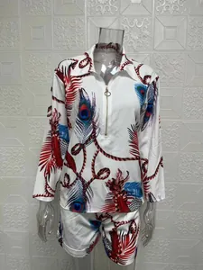 Detail view of two-piece women's set with long sleeves and bold peacock feather print motif.
