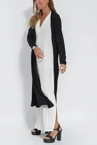 Elegante set composto da abito lungo bianco smanicato con scollo a V e cardigan nero lungo