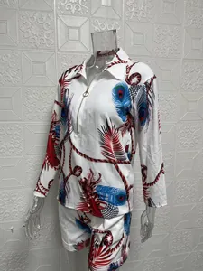 Detailed view of women's two-piece set with vibrant peacock feather and rope print