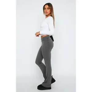 Donna che indossa leggings svasati grigi a vita bassa e un crop top bianco a maniche lunghe