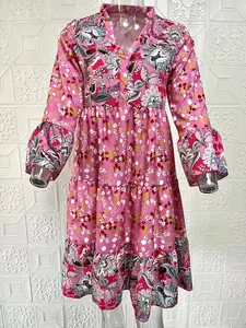Detailed view of a vibrant pink floral print V-neck tiered dress with long puff sleeves