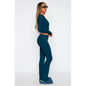 Vista laterale di una donna che indossa un set chic di crop top a maniche lunghe e pantaloni.