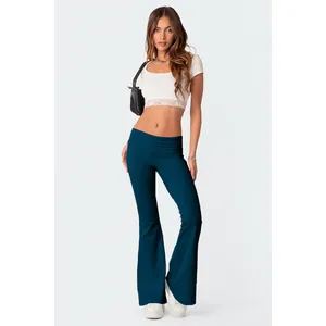 Pantaloni a zampa a vita bassa verde petrolio con crop top in pizzo bianco alla moda