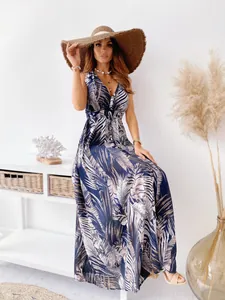 Detail view of the tropical leaf print and V-neckline of a flowy summer maxi dress