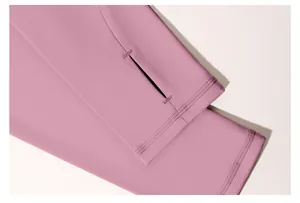 Nahaufnahme eines rosafarbenen Yoga-Tops mit Daumenloch und flachen Nähten am Ärmel.