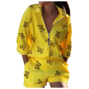 Close-up of yellow two-piece lounge set with black butterfly print and ring zipper pull
