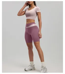 Detail view of pink and purple color-block yoga set with short sleeve crop top and shorts
