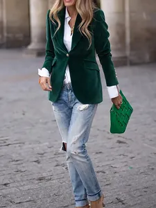 Close-up of a women's dark green velvet slim-fit blazer with gold button detail