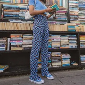 Full length view of a model wearing high-waisted blue and brown checkerboard pants