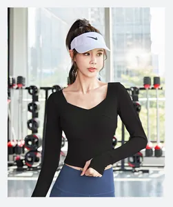 Macro view of black long-sleeve yoga top with cross V-neck and built-in chest pads